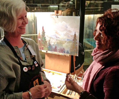 Amy Evans talks with Cynthia Morris during a painting demo on gallery walk night at the CCI Summit in Breckenridge.