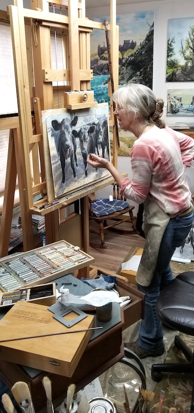 Jan Clizer peers at her easel at a work in progress | in Art Biz Success