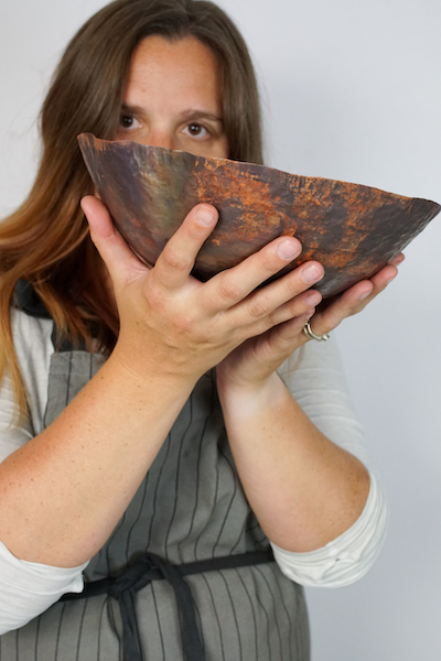 Megan Auman metal artist holding copper bowl | on Art Biz Success
