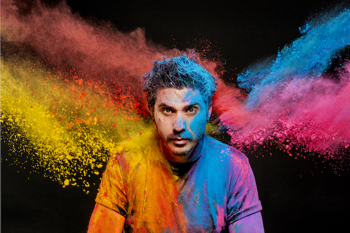 artist Rich Simmons with colorful paint thrown around behind him| on Art Biz Success