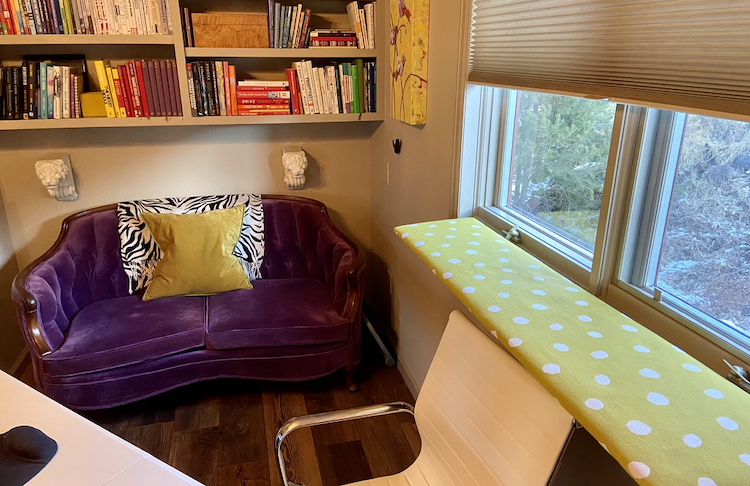 purple sofa with bright polka dot cat perch by the window