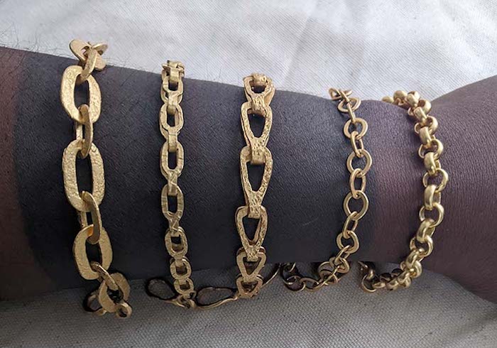 arm stacked with gold link bracelets artist Alicia Goodwin | on Art Biz Success