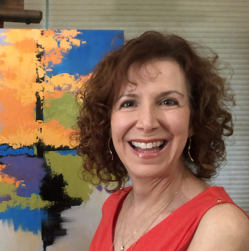 Artist Lynn Goldstein in a red shirt and smiling big in front of one of her abstract landscape paintings | on Alyson Stanfield