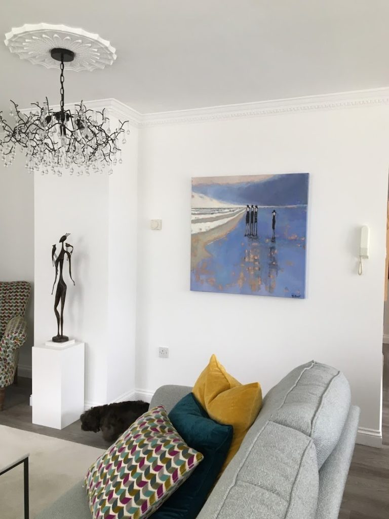 blue painting hanging on a white wall in a living room | on Art Biz Success