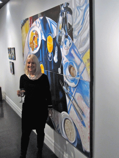 Barbara Muir in front of her painting, Breakfast in the Hotel. Acrylic on 4 canvases, 72 x 96 inches, ©2012.
